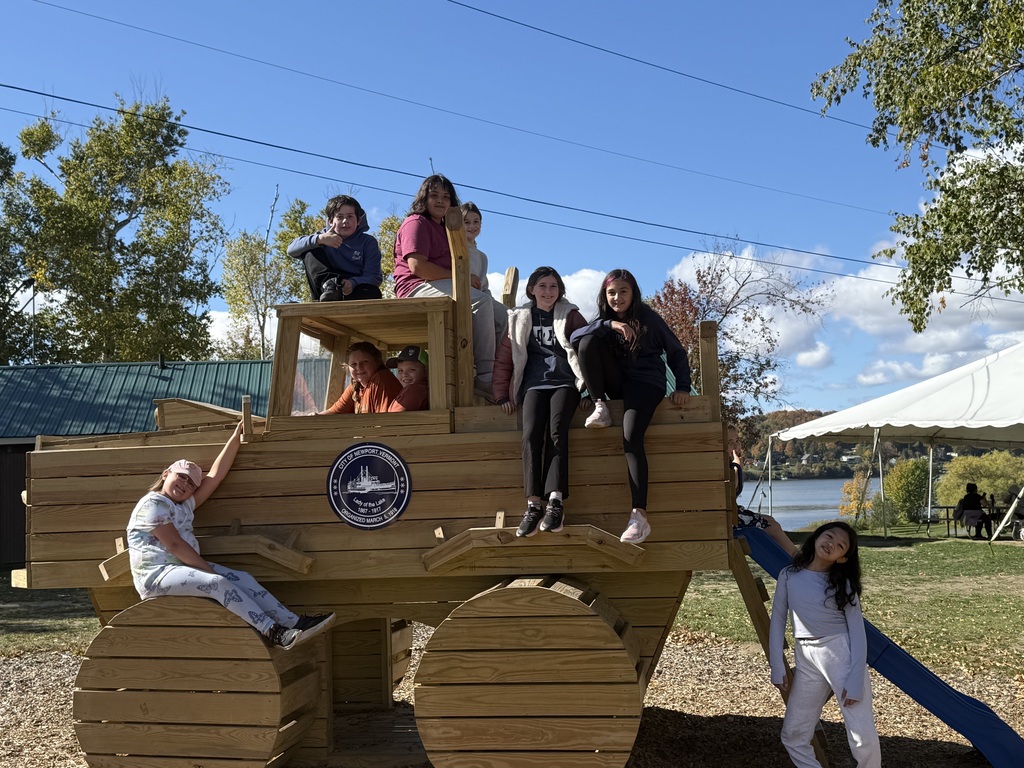 a group of students sitting on a wooden tractor at Gardner Park