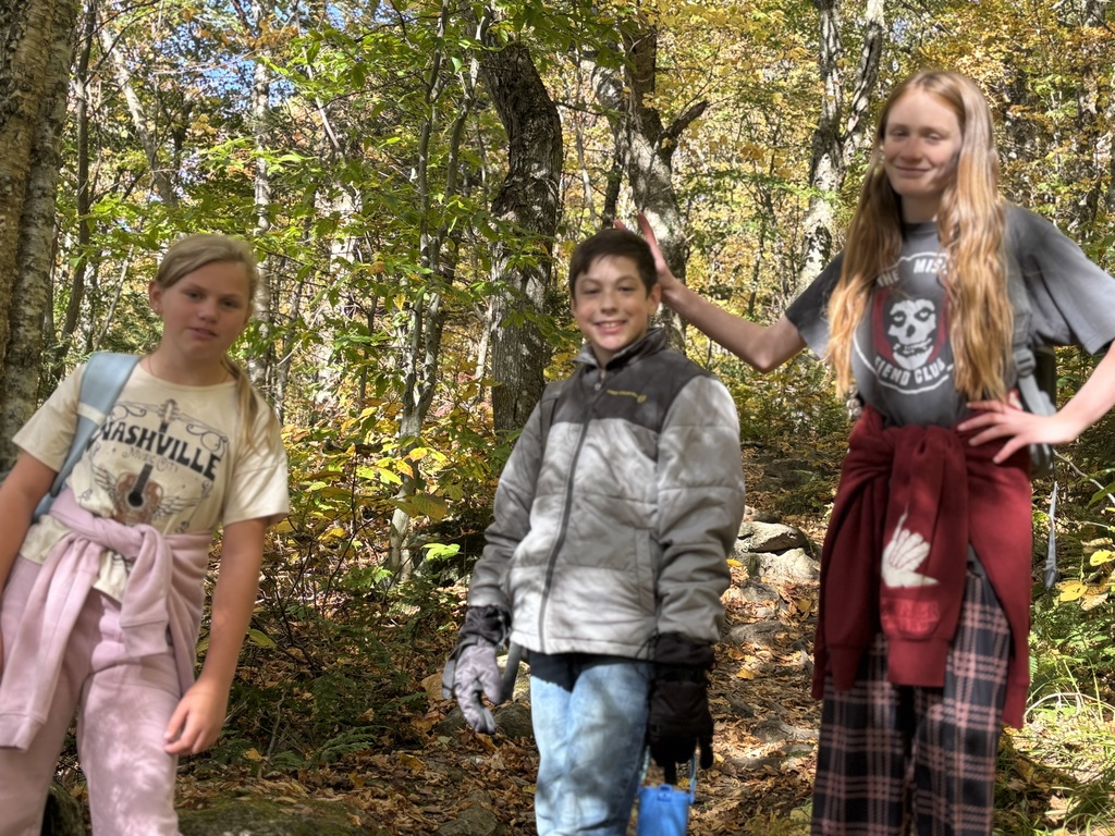 three students posing in the woods