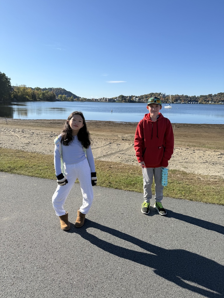 Two students standing side by side in front of lake Memphremagog