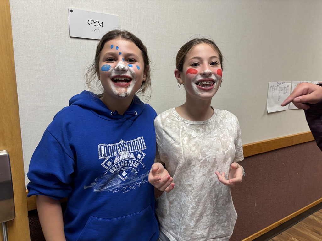 a sixth grade and seventh grade student with whipped cream and face paint on their faces