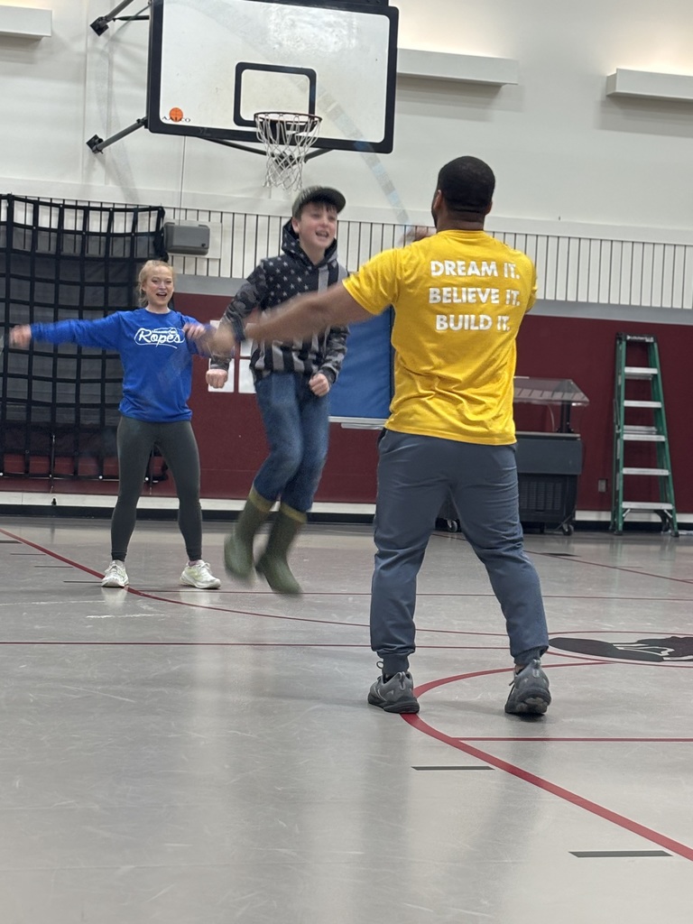 A 5th grade student  jumps while Nick and Kaylee from Learnin' the Ropes uses their jump ropes with him