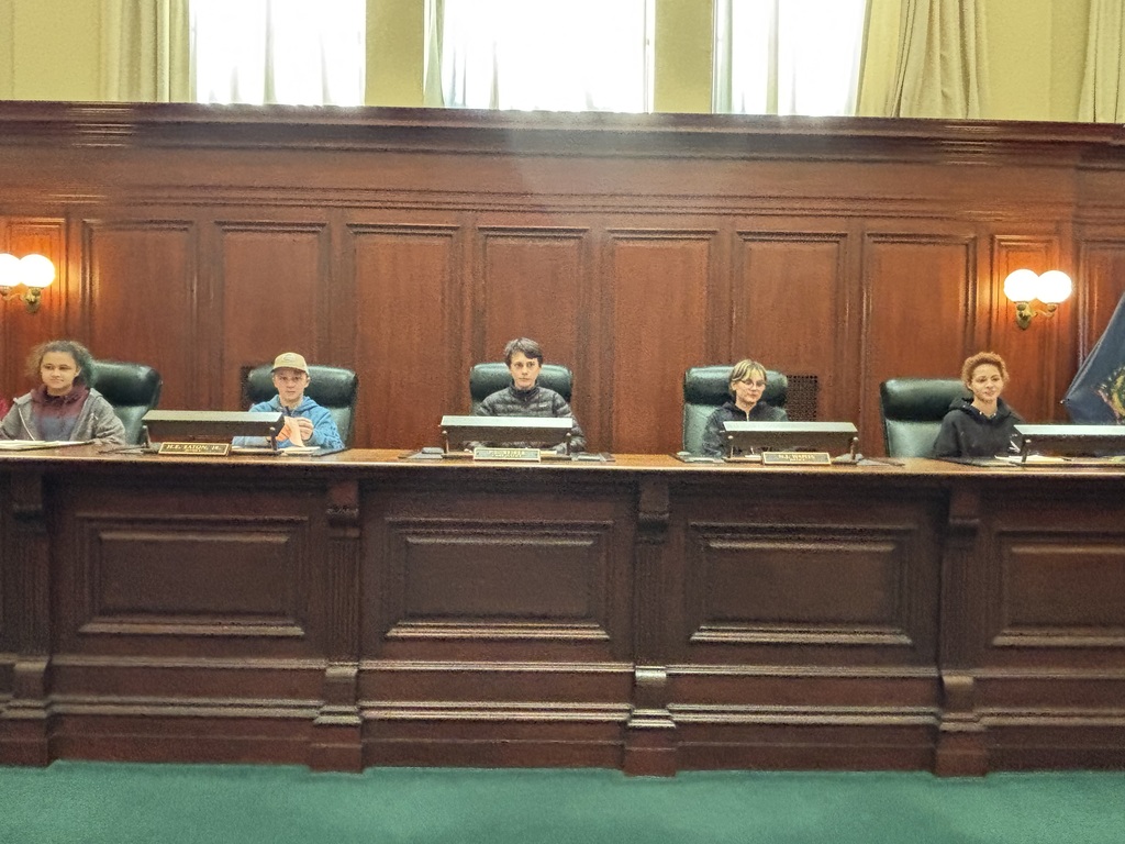 8th grade students sit in the chairs of the supreme court's justices and act as the justices for their mock trial 
