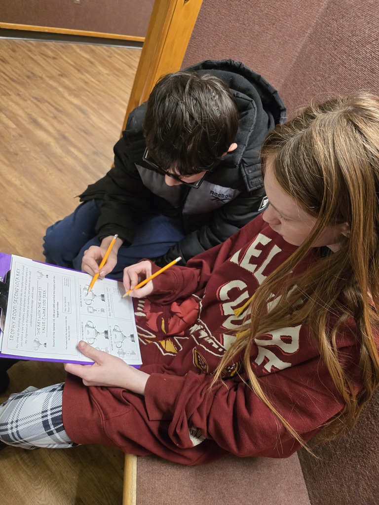 Two 6th grade students work on a scavenger hunt for math 