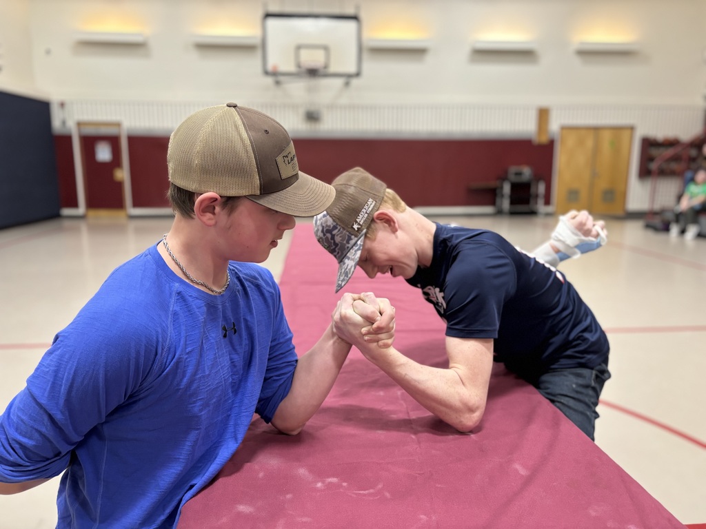 Two 8th grades arm wrestling 