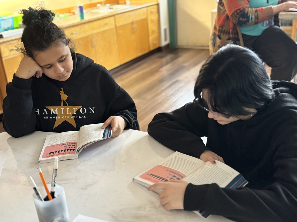 an 8th grade girl and boy reading for social studies