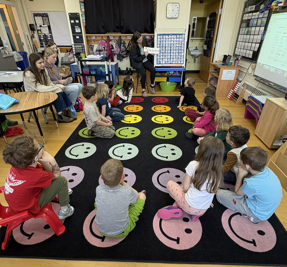 High school students reading to kindergartners