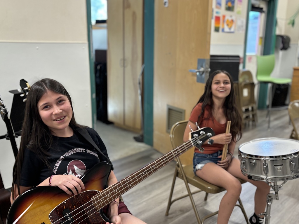 two 6th grade girls are practicing their instruments (bass and drum) in band