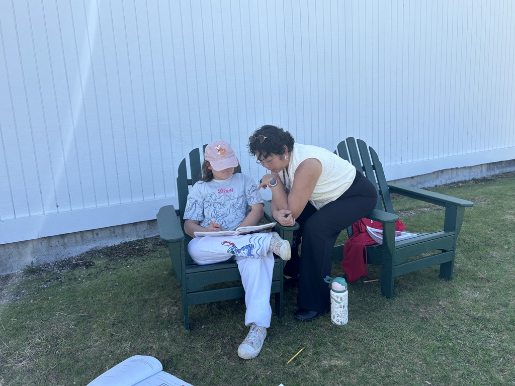 Ms. Phun works with a 5th grader on her math in the sunshine