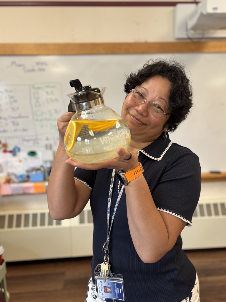 Ms. Phun holds a coffee pot with water and lemon slices