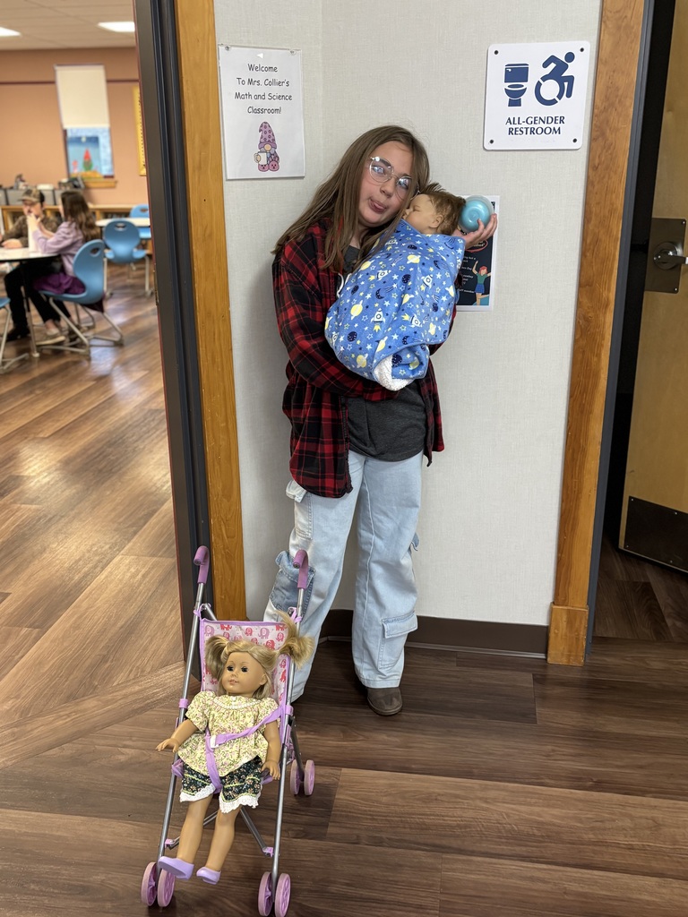 a 5th grade dressed as Ms. Collier. Holding a baby doll and a stroller