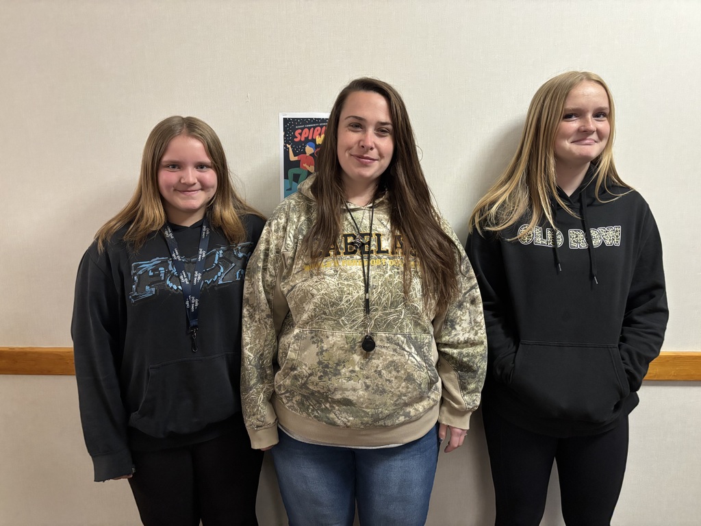 A 7th grade girl and an 8th grade girl are posing with Ms. Erica, who they dressed as