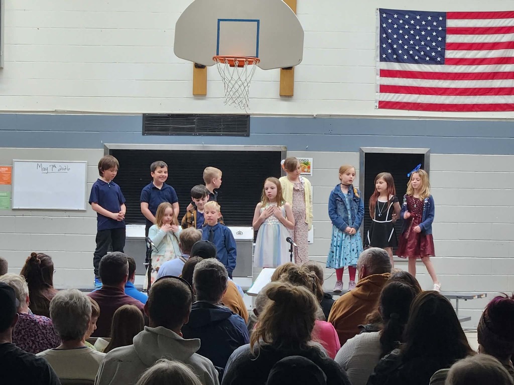 students performing songs on the riser in front of audience 