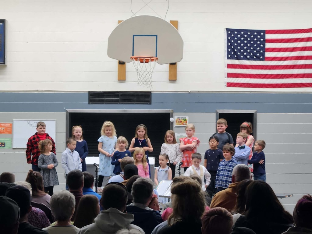 students performing songs on the riser in front of audience 