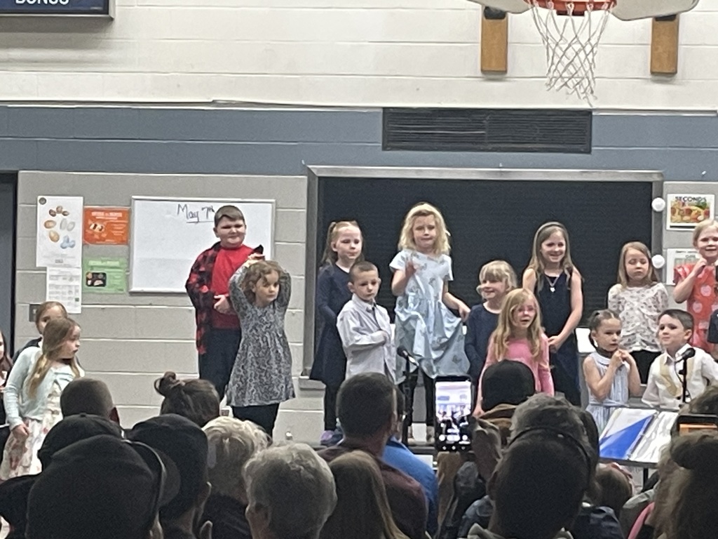 students performing songs on the riser in front of audience 