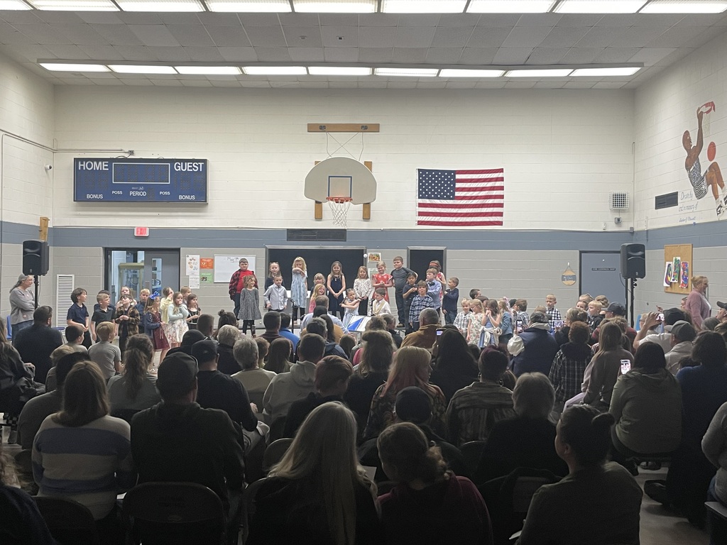 students performing songs on the riser in front of audience 