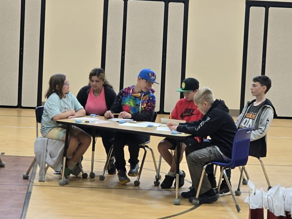 Albany Students sitting around a table figuring out a math problem at the Math Olymiads