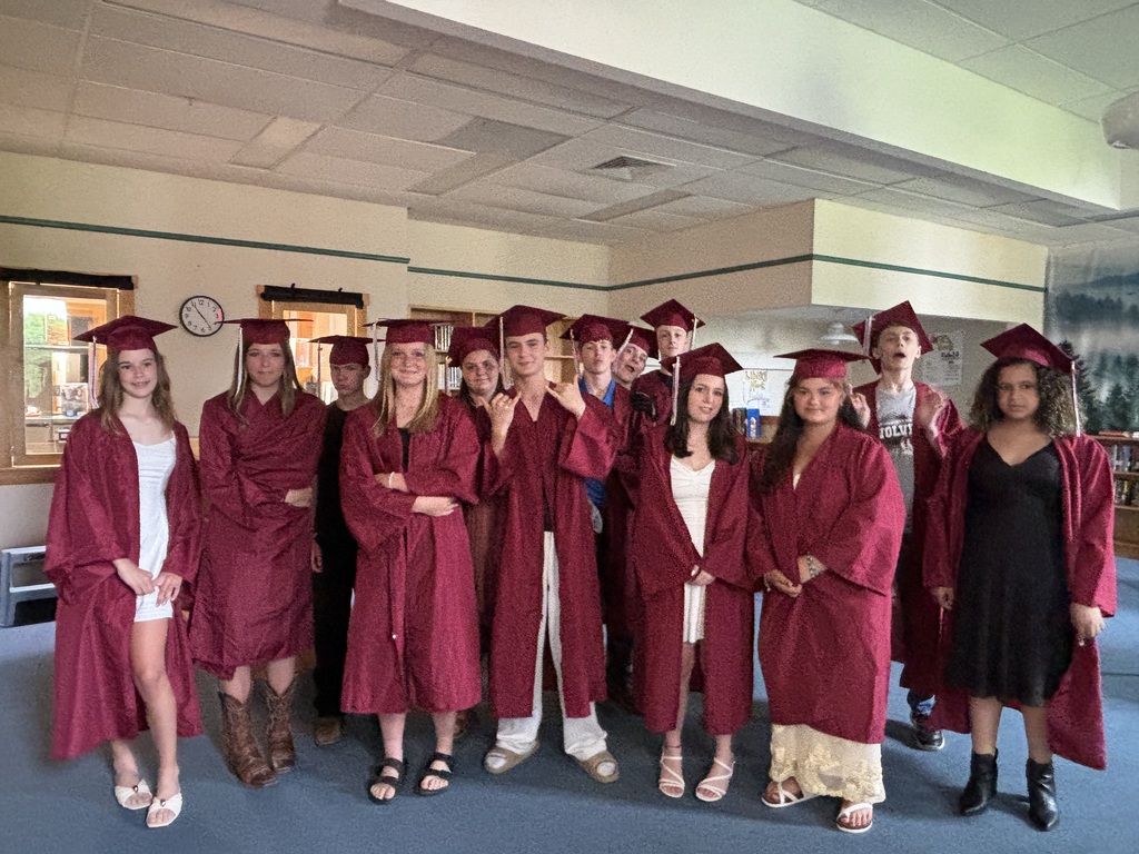 8th grade class posing with their caps and gowns on