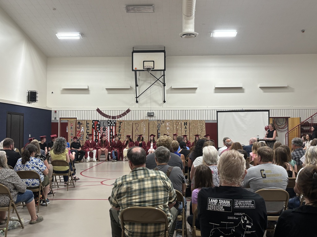 the 8th graders sitting and the audience looking on as Ms. Thomas delivers her speech