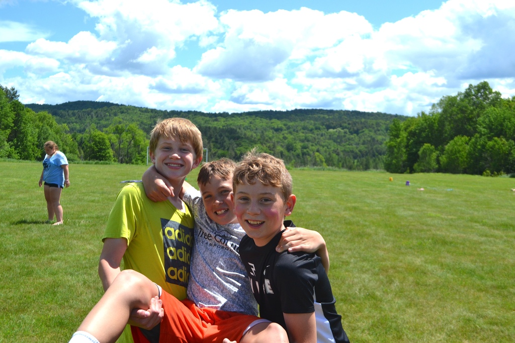 5th grade boys smile for the camera before a beautiful mountain view on campus
