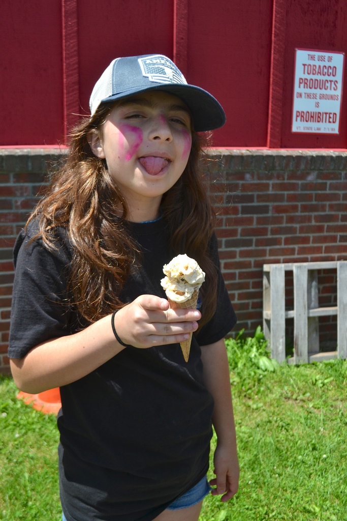 a 5th grade girl smiles for the camera holding an ice cream cone