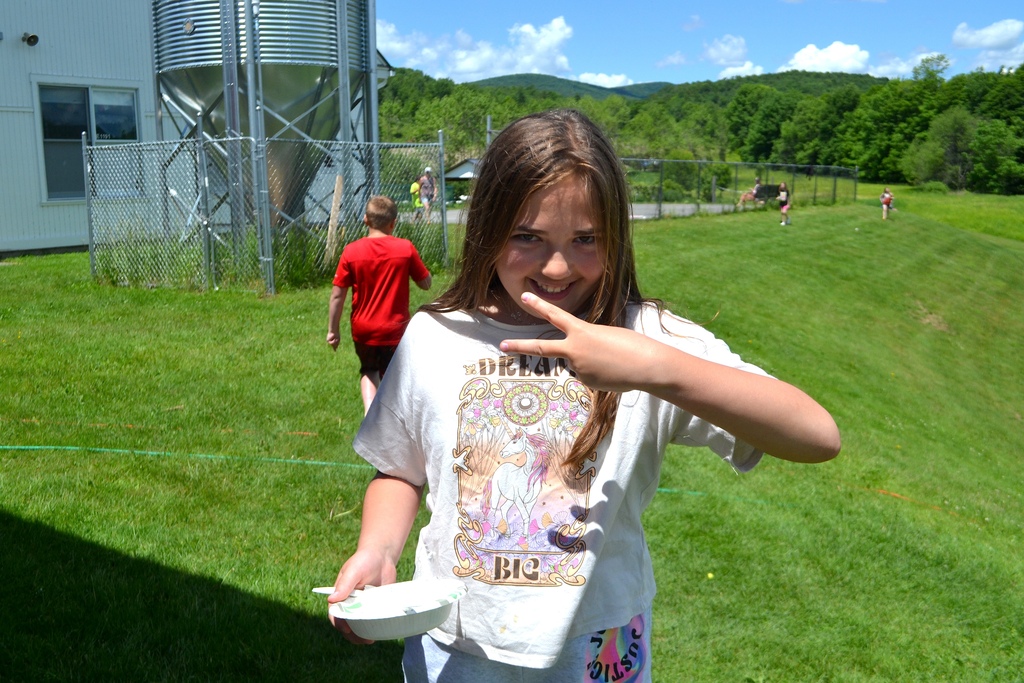a 5th grade girl throws a peace sign to the camera