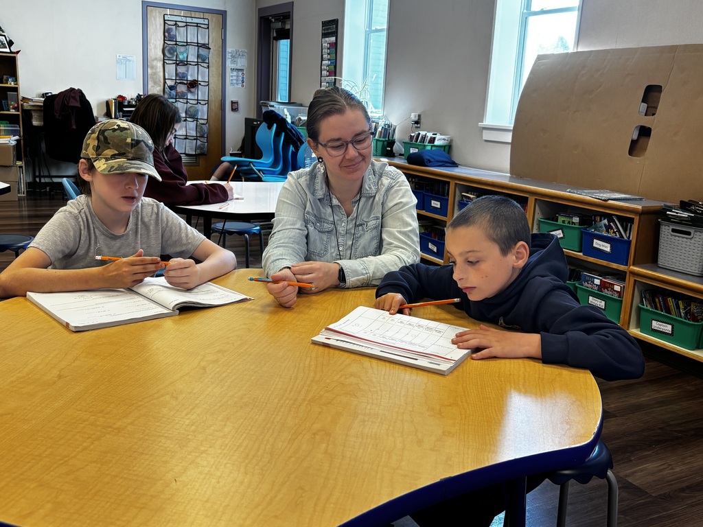 Ms. Collier works at a table with two 5th graders