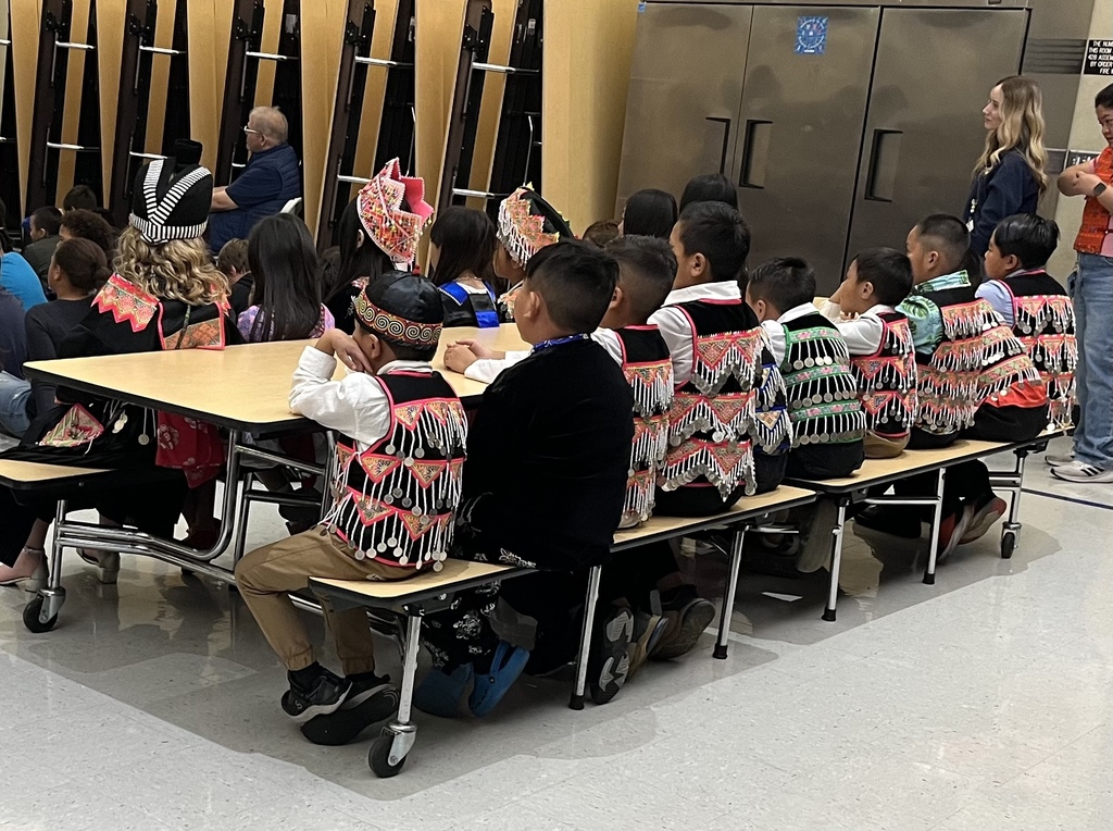 Students sitting in the cafeteria watching the show