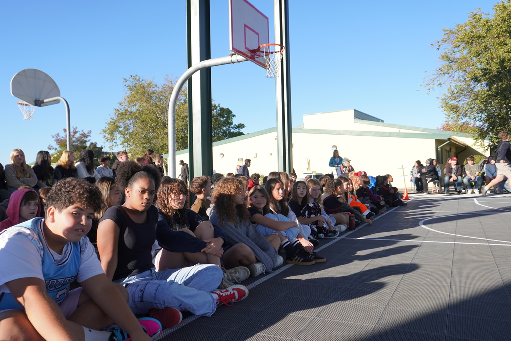 Students sittingon the ground at the pavilion