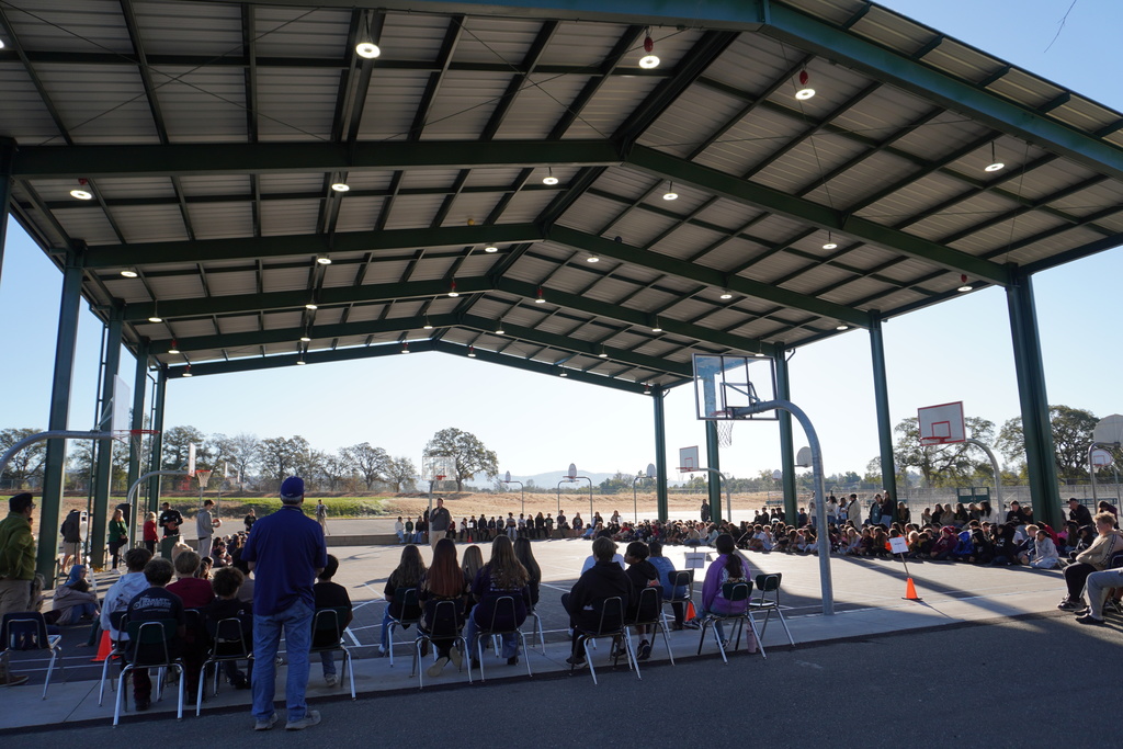 Students watching the presentation at the sports pavilion