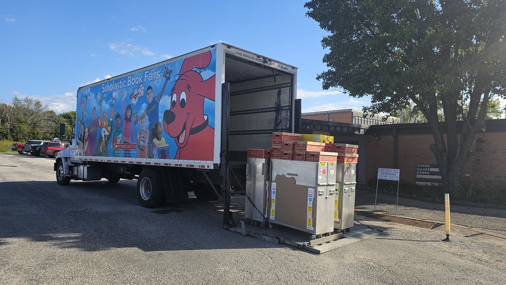 Scholastic truck dropping off book fair cases.