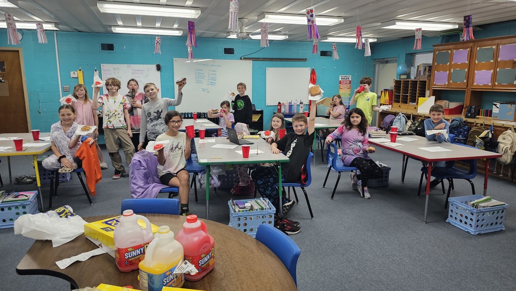 Students holding donuts for a group picture.