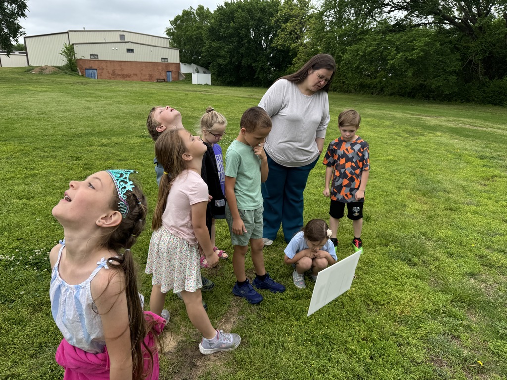 Students gather around a story sign to read it.