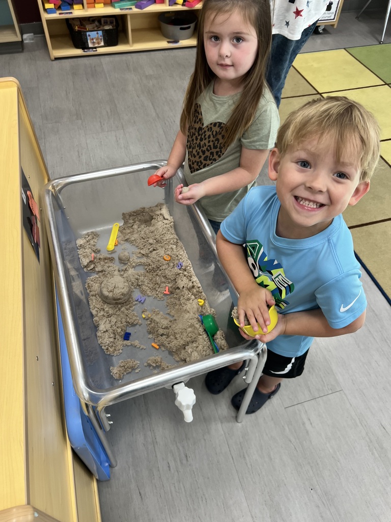 Two oskaloosa preschoolers playing with sand. 