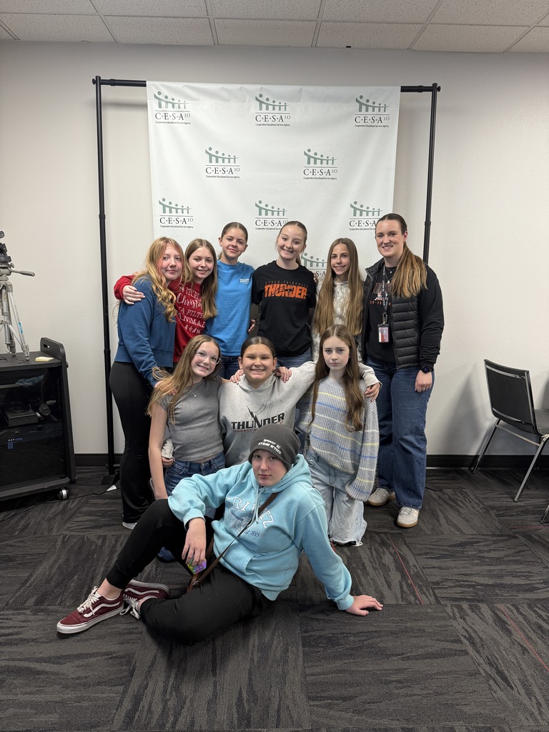 Student group posed in front of banner
