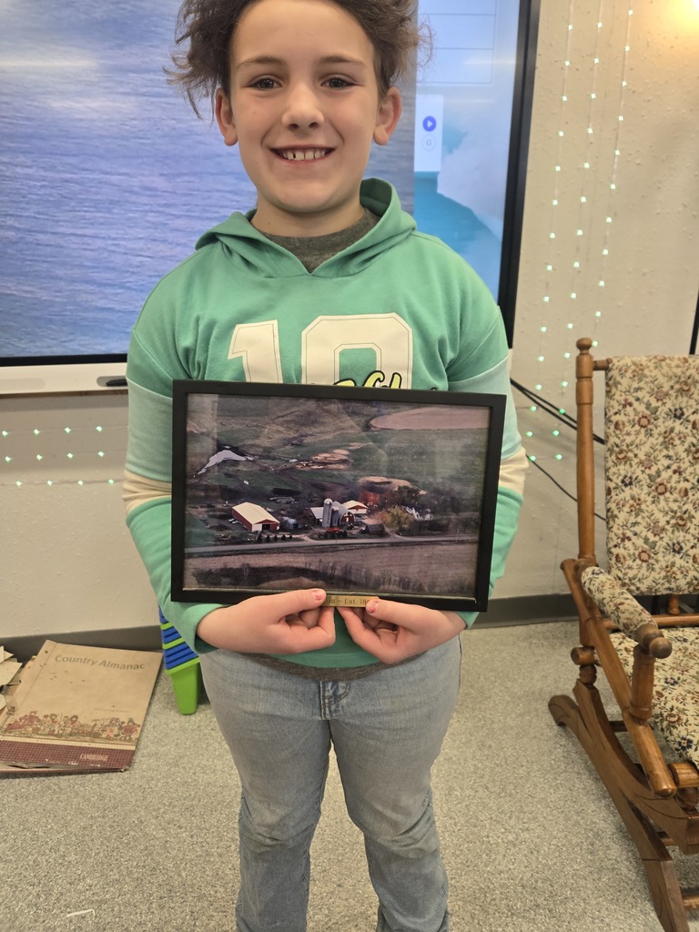 Student holding photo of family farm