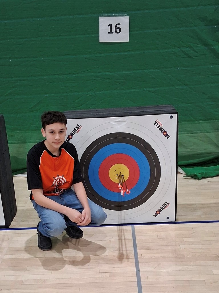 Cole in front of archery target