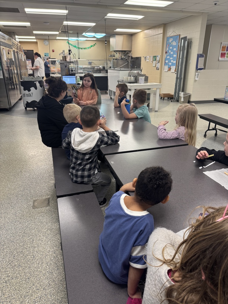 Student reading to younger students