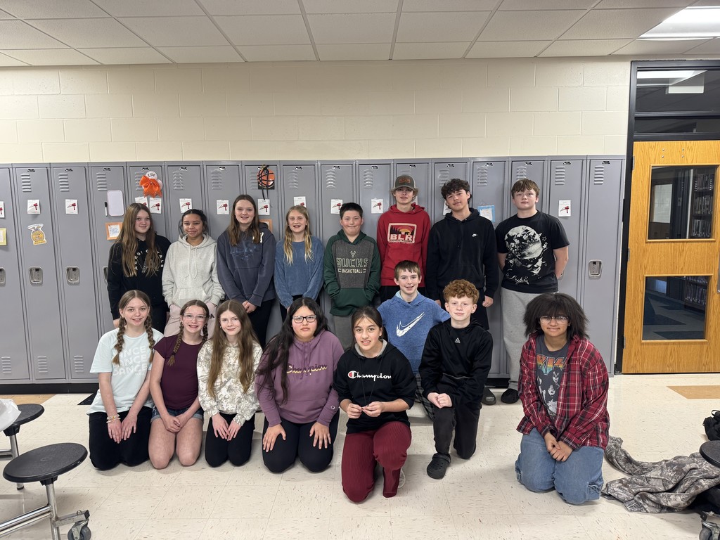 Group of MS students standing in front of lockers.