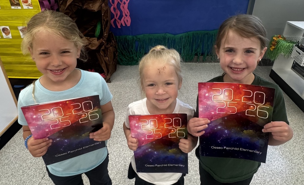 students holding elementary yearbooks.