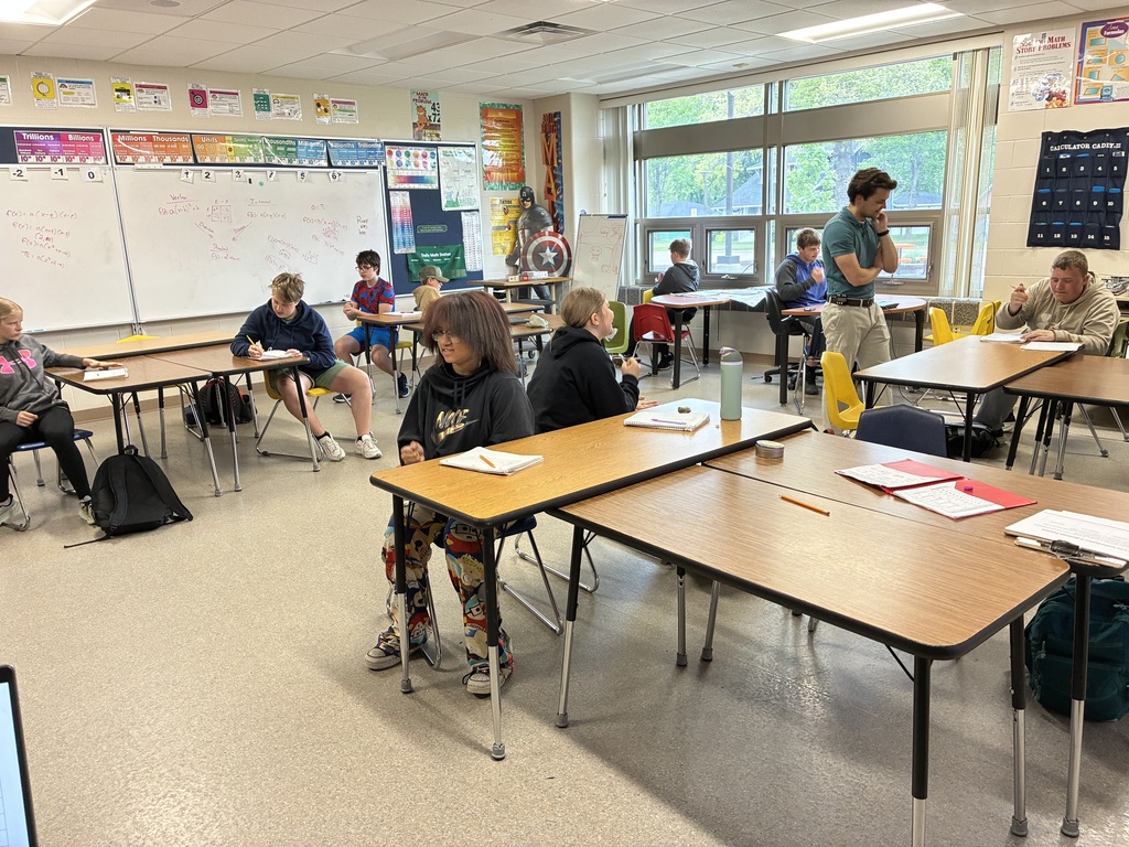 students in class sitting at tables rock paper scissors
