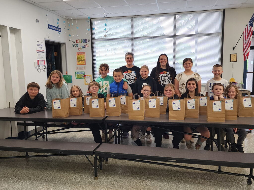 Group picture of student lunch hero helpers with gift bags.  