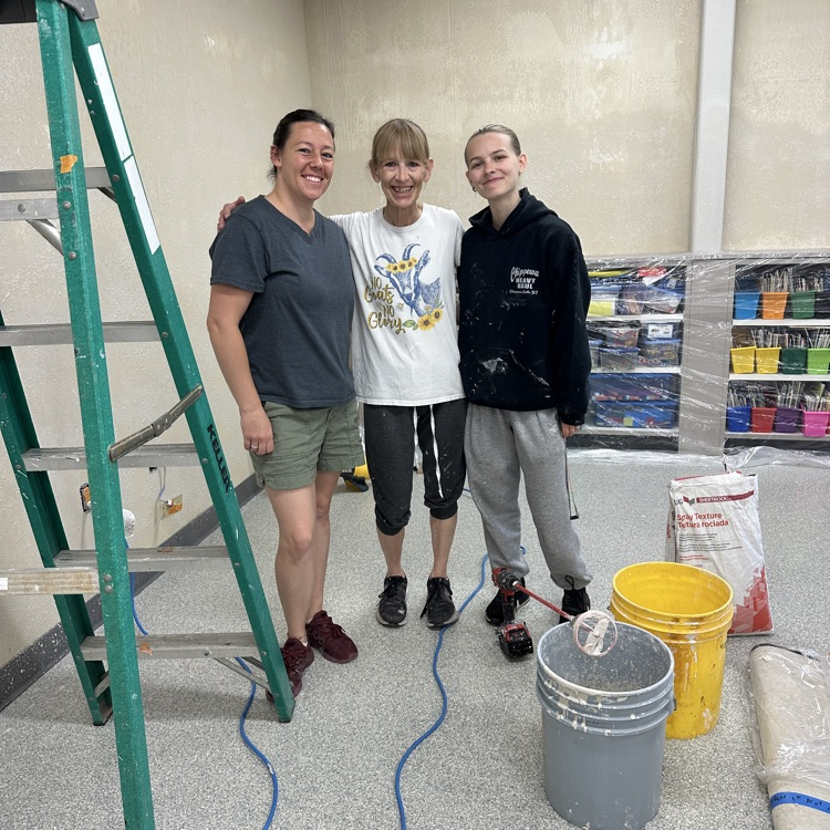 three women posing by ladder