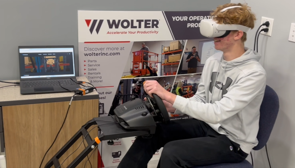 Student using VR goggles in front of Wolter Sign