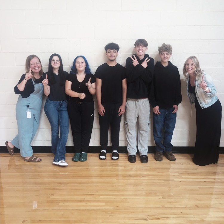seven people all wearing black shirts 