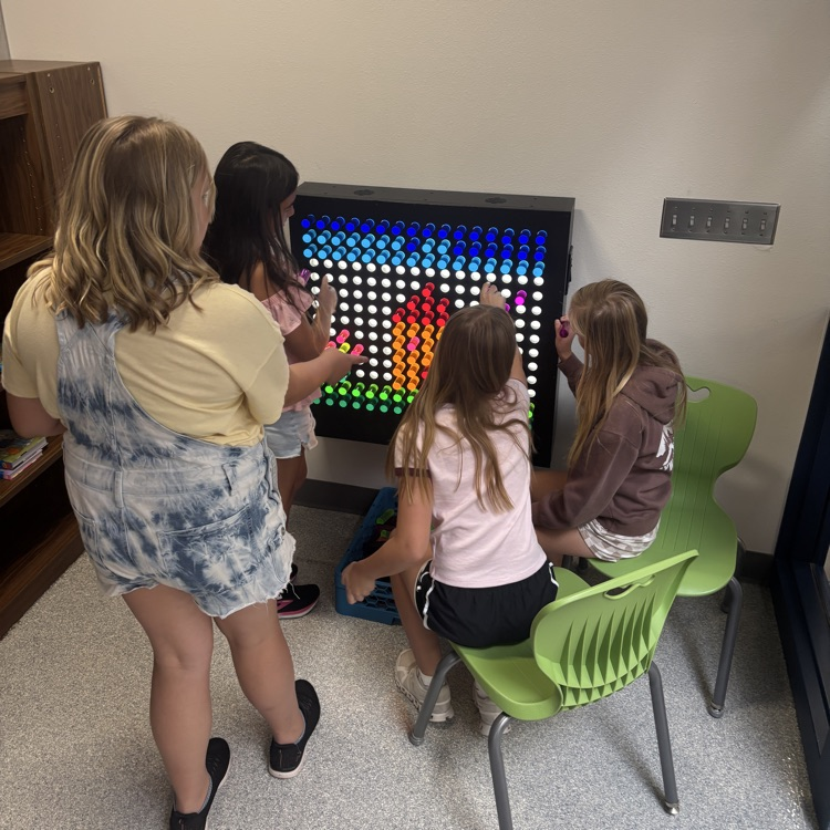 four girls working on giant light brite