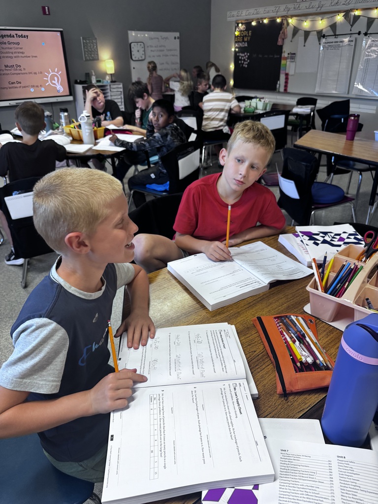 students working in math workbooks