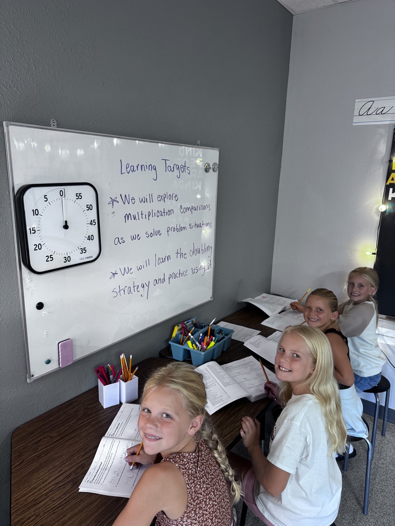 4 girls working in math workbooks