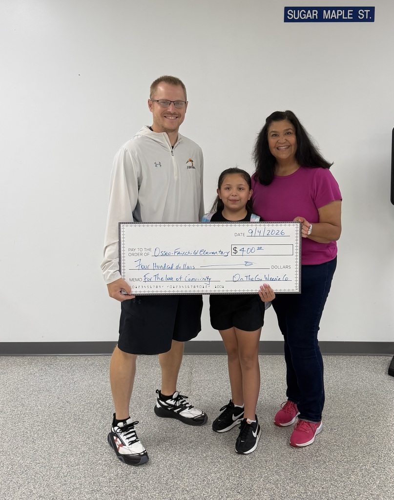 Principal accepting large check donation for $400 from student and adult