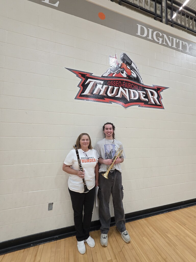 community members that played with pepband   Standing under thunder logo holding instruments