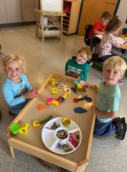 three students working with playdough